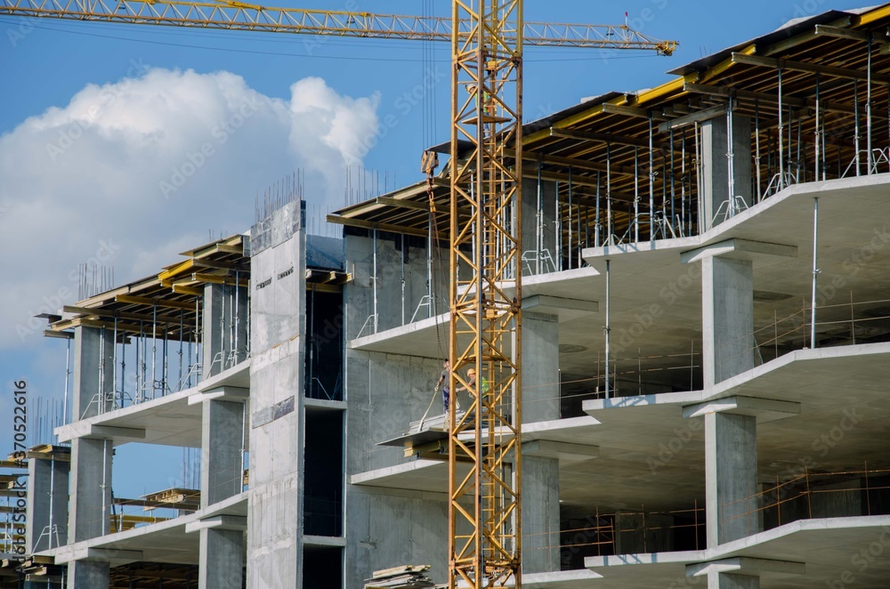 The structure of the sky crane. Construction process background. Monolithic building yellow crane background.