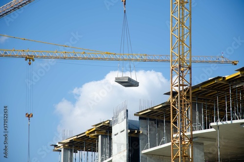 The structure of the sky crane. Construction process background. Monolithic building yellow crane background.