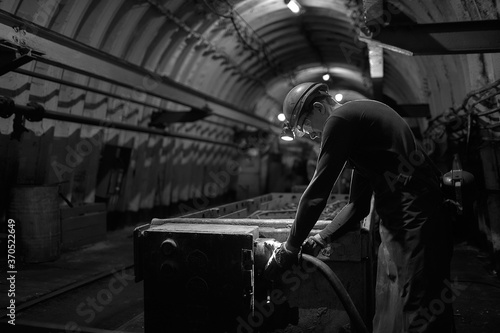 Silhouette of a working miner in a mine