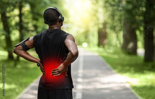 Black sportsman touching sore zone on his back
