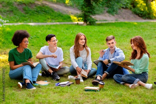Students Leisure. Group of multiethnic college friends studying together outdoors at campus