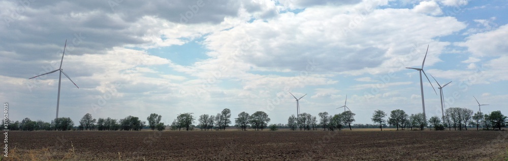 Europe, Odessa region, Ukraine - August 2020: Wind power plants on the field against the background of the sea.