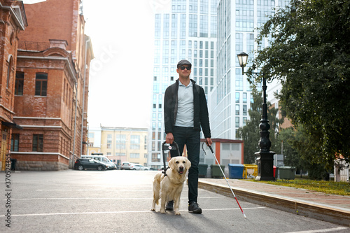 Foto the concept of the young blind invalid and the dog guide, little golden retrieve