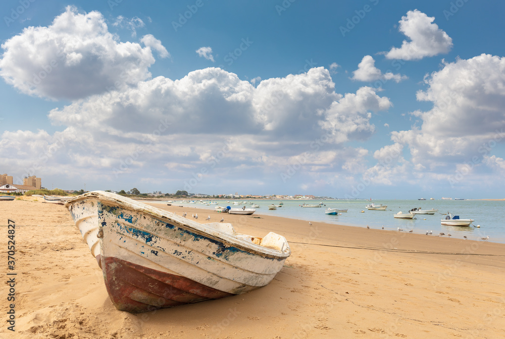At the mouth of the river there is a fishing boat on the beach of Bonanza. There are many other boats to be seen. In the background are larger ships and the Atlantic. At the mouth of the river there is a fishing boat on the beach of Bonanza. There are many other boats to be seen. In the background are larger ships and the Atlantic.
