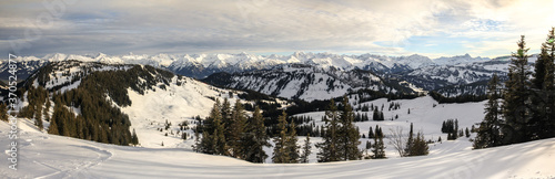 Snow covered mountains and trees. Amazing Panoramic snowy winter landscape in Alps at sunrise morning. Grasgehren Ski Resort, Allgau, Bavaria, Germany.