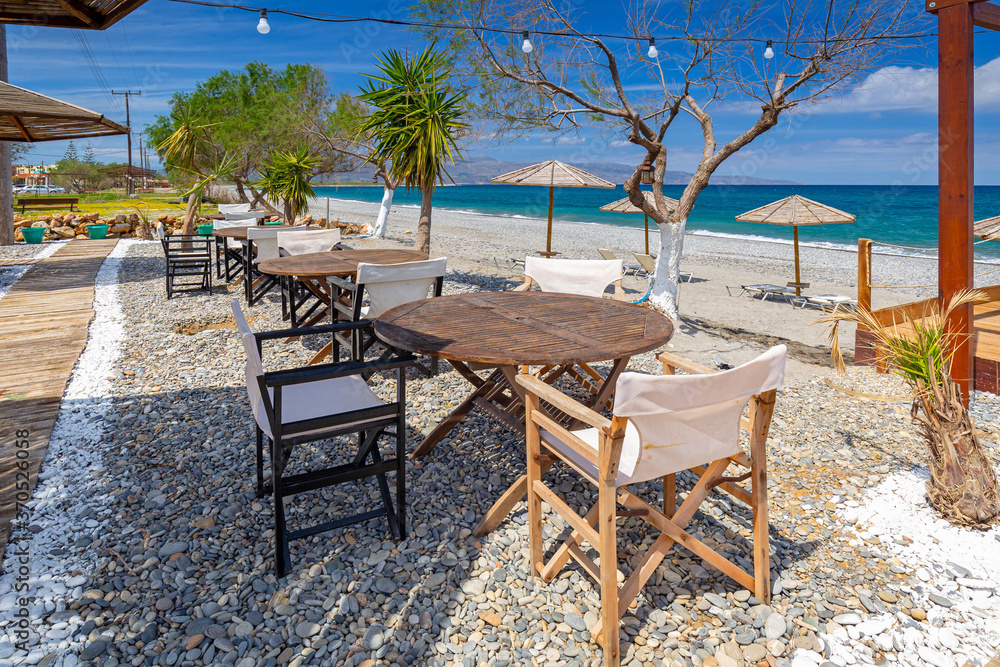 Empty restaurant tables at the Maleme beach on Crete, Greece