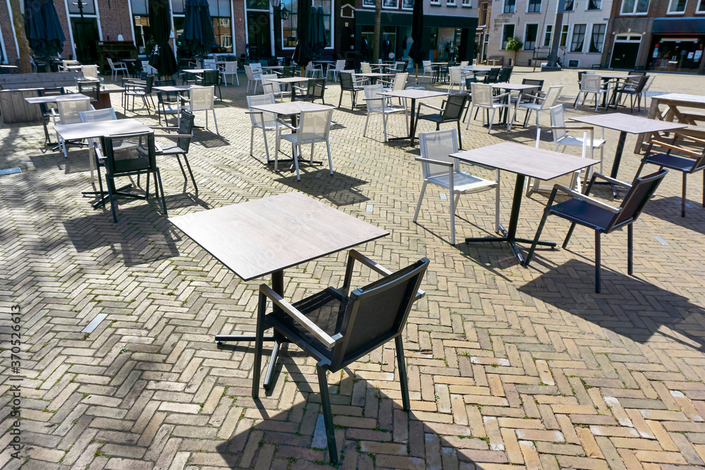 Empty terrace of a closed restaurant in The Netherlands with plenty of space between tables and chairs during coronavirus restrictions waiting to reopen. Social distancing concept.