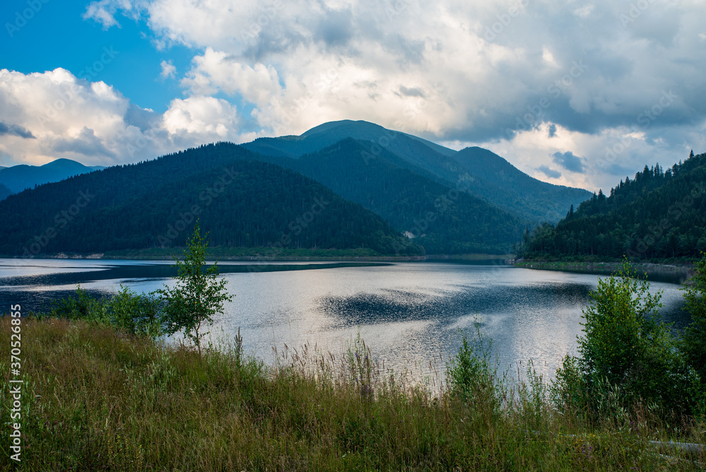 Gura Apei lake with Godeanu mountain range on the background in Romania