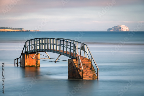 The Belhaven Bridge, Dunbar, Scotland.. Also known as the Bridge to Nowhere, as although it crosses the River Biel, its base is submerged at high tide. The Bass Rock can be seen in the distance.