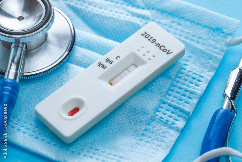 Home blood test for COVID-19 on blue background with medical mask and stethoscope. Home blood test for COVID-19 on blue background with medical mask and stethoscope.