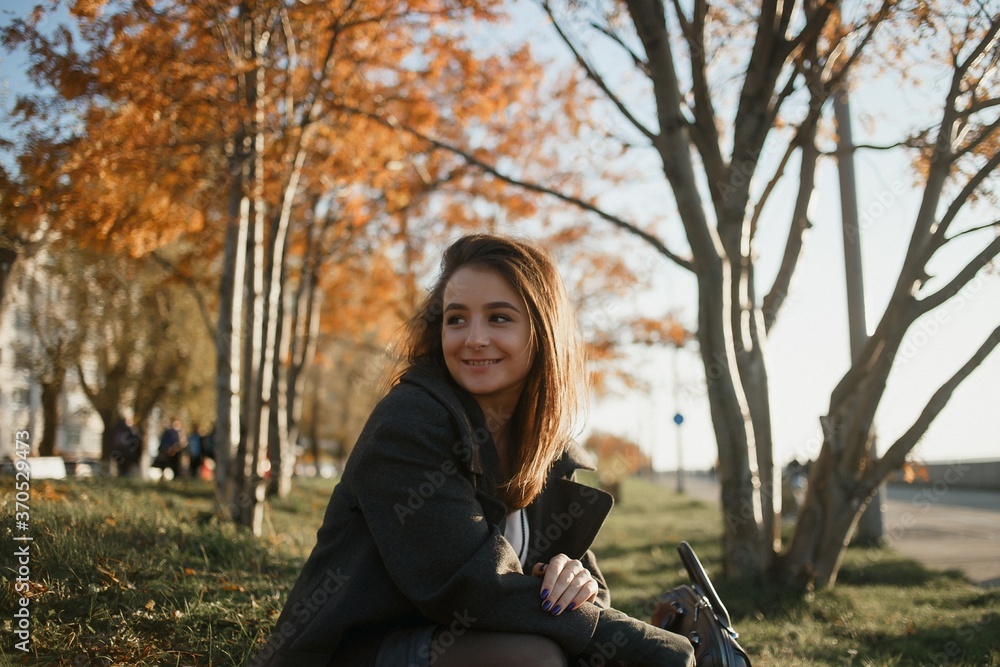 Outdoor fashion photo of young beautiful lady in red scarf and dark grey coat surrounded autumn landscape. Outdoor fashion photo of young beautiful lady in red scarf and dark grey coat surrounded autumn landscape.