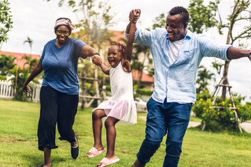 Portrait of enjoy happy love black family african american father and mother with little african girl child smiling running and having fun moments good time in summer park at home
