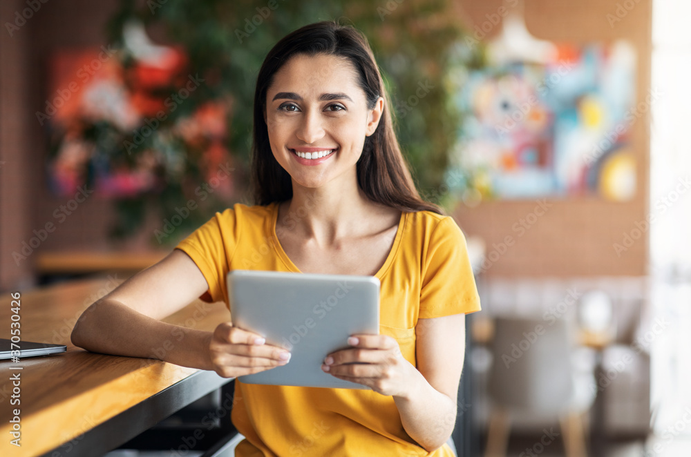 Pretty young woman using digital tablet at cafe Pretty young woman using digital tablet at cafe