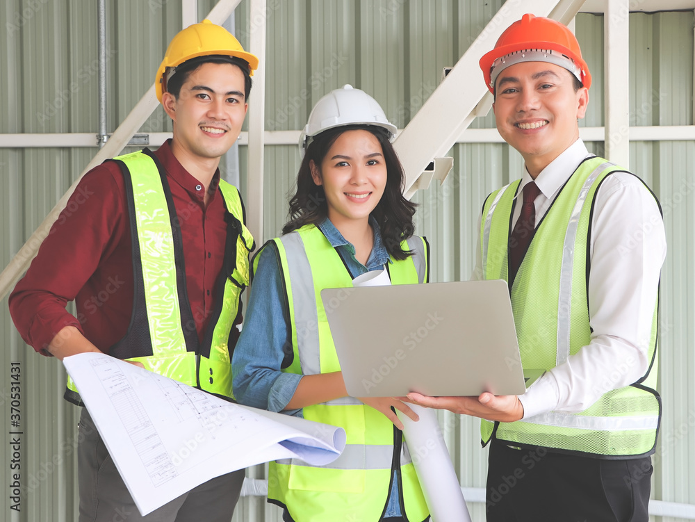 three confident construction team, a female architect and two male engineers, wearing safety helmets,holding computer and blue print paper , smile and looking at camera. three confident construction team, a female architect and two male engineers, wearing safety helmets,holding computer and blue print paper , smile and looking at camera.