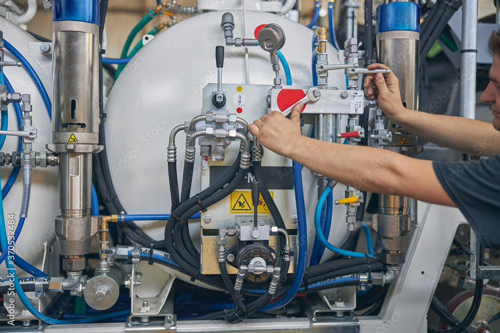 Competent mechanic doing checkup of pressure in unit Competent mechanic doing checkup of pressure in unit