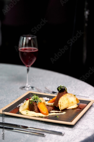 red wine and delicious meat on plate in restaurant, tasty food on table