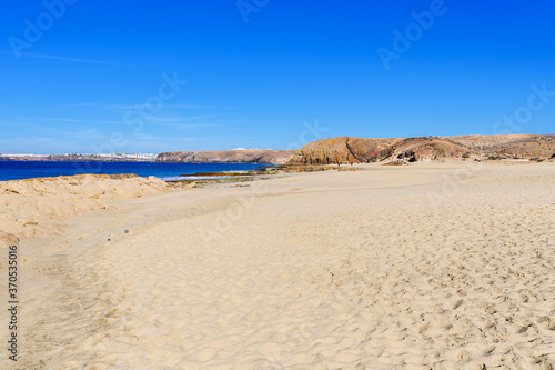 View of beautiful Playa de la Cera beach, blue sea, yellow sand, cliffs. Papagayo, Playa Blanca, Lanzarote, Canary Islands, selective focus