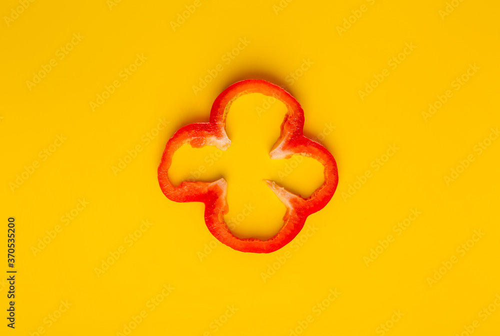 One slice of red pepper at yellow background One slice of red pepper at yellow background