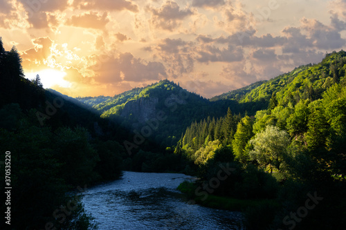 Dramatic summer sunset with beautiful sky and mountains and river © raresb