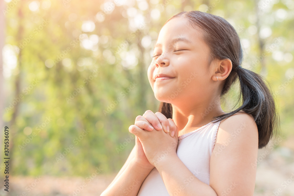 cute little girl hands praying to god with the bible in the morning on nature background. little asian girl hand praying for thank god. copy space. spirituality and religion faith hope concept. cute little girl hands praying to god with the bible in the morning on nature background. little asian girl hand praying for thank god. copy space. spirituality and religion faith hope concept.