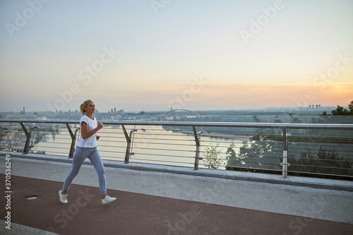 Fototapeta Naklejka Na Ścianę i Meble -  Professional Caucasian female athlete working out outdoors