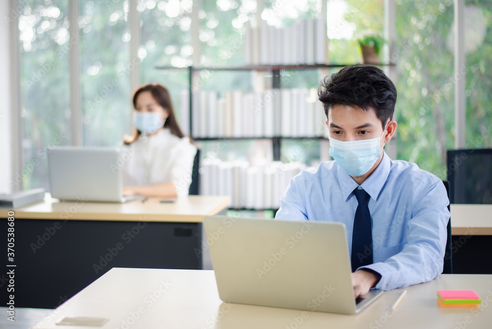 Asian business people with medical mask for virus protection working in office. new normal and social distancing concept. Asian business people with medical mask for virus protection working in office. new normal and social distancing concept.