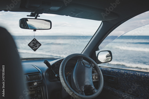 view of the ocean with large waves from the dark interior of the car © Aleksandra