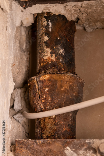Rusted built-in cast iron sewer pipe damaged with a crack
