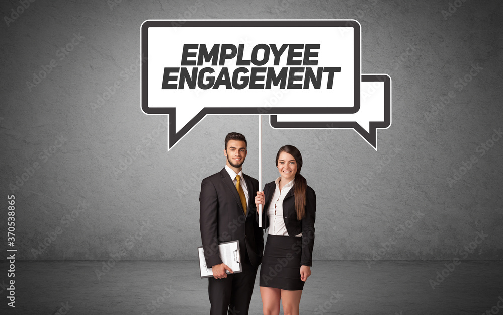 Young business person in casual holding road sign with EMPLOYEE ENGAGEMENT inscription, new business idea concept Young business person in casual holding road sign with EMPLOYEE ENGAGEMENT inscription, new business idea concept