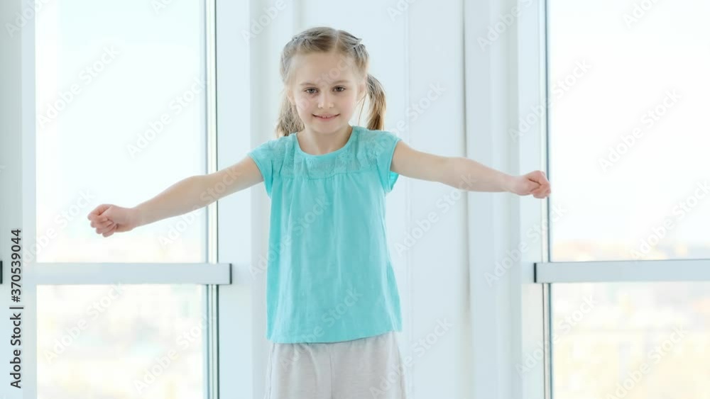 Beautiful little girl doing warm up indoors Beautiful little girl doing warm up indoors