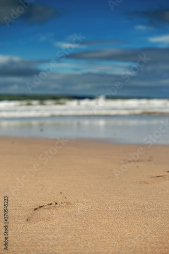 Yellow sand in focus, ocean wave and blue sky out of focus, Abstract nature background.