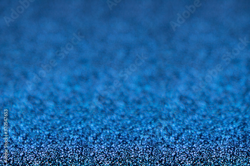 Abstract glitter christmas blue background. Shimmer bright background with bokeh defocused blue lights. Shiny gradient with copy space