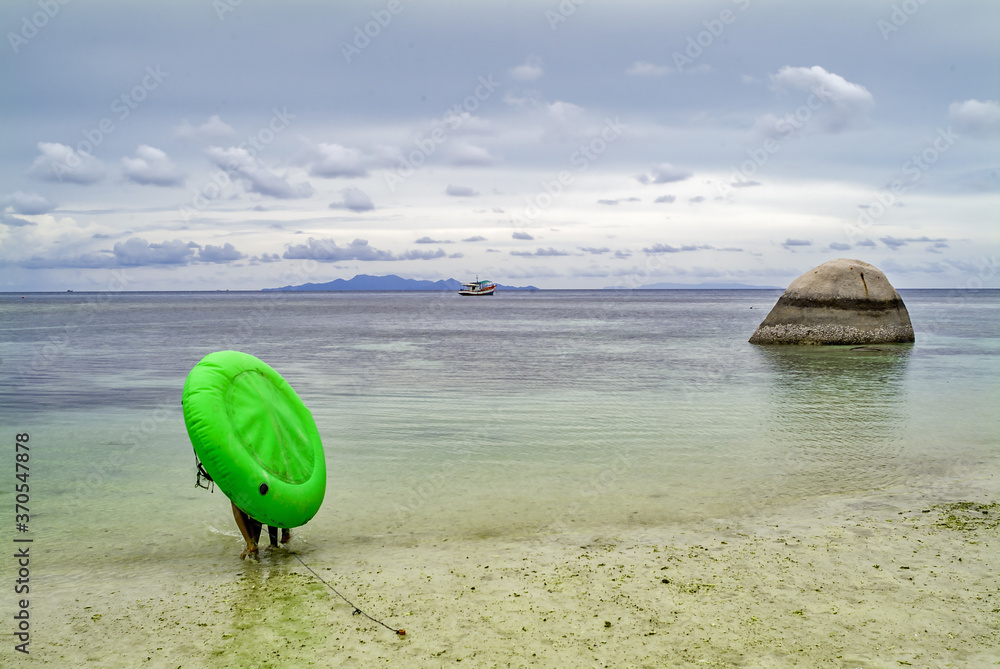 and inflatable canoe and smooth rocks and emerald sea at Koh Tao island, Thailand and inflatable canoe and smooth rocks and emerald sea at Koh Tao island, Thailand