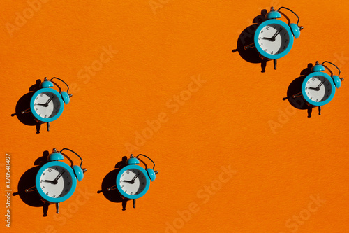 Blue alarm clock on orange background. Back to school concept. Creative design, minimal flat lay concept. photo