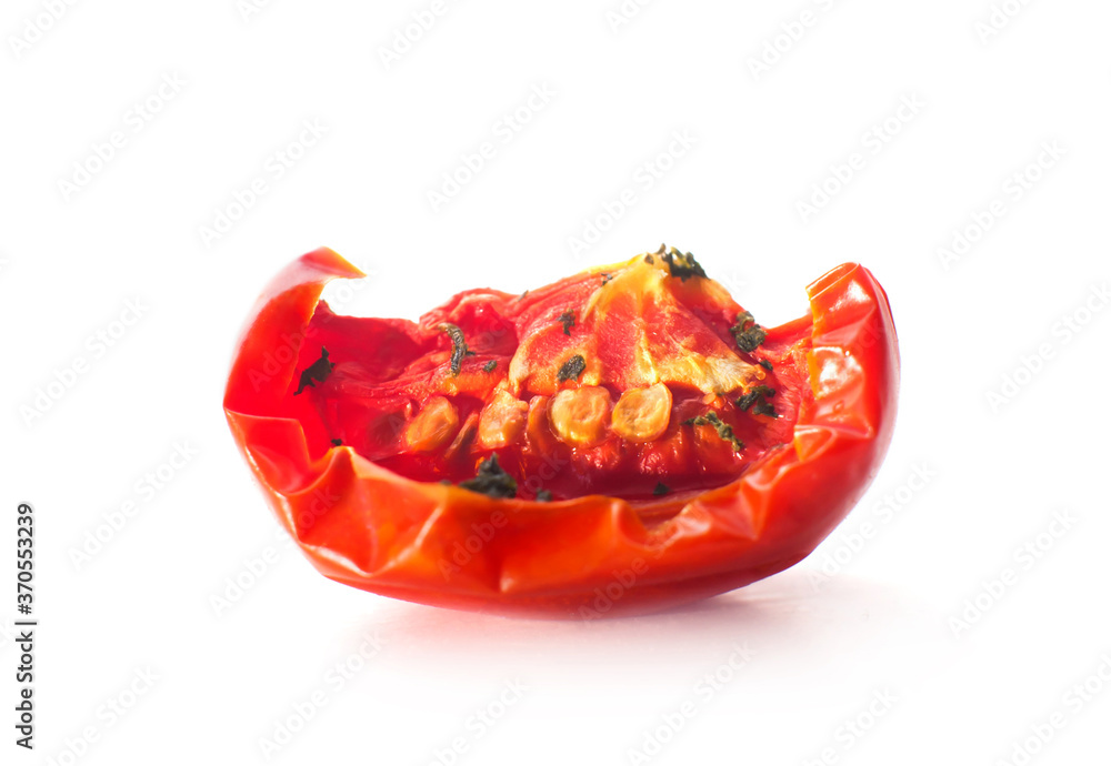 Slice of red dried tomato with spices close-up. Isolated on white background. Macro. Slice of red dried tomato with spices close-up. Isolated on white background. Macro.