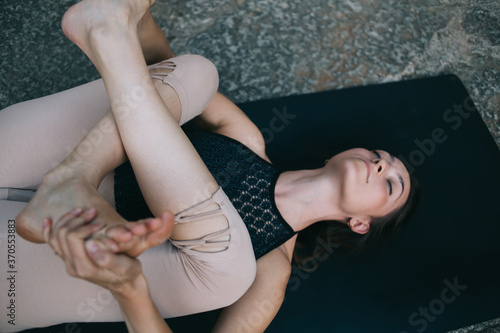 Flexible woman practicing yoga on mat