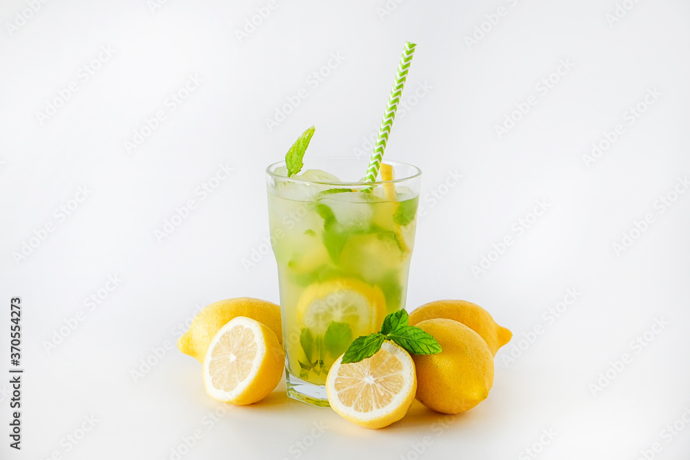 Single glass of iced lemonade. Studio shot of refreshing non alcoholic mojito drink with lemon slices, mint leaves and ice isolated on white background, close up, copy space. Single glass of iced lemonade. Studio shot of refreshing non alcoholic mojito drink with lemon slices, mint leaves and ice isolated on white background, close up, copy space.