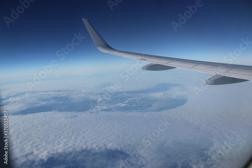 view to space from airplane above the clouds and left wing