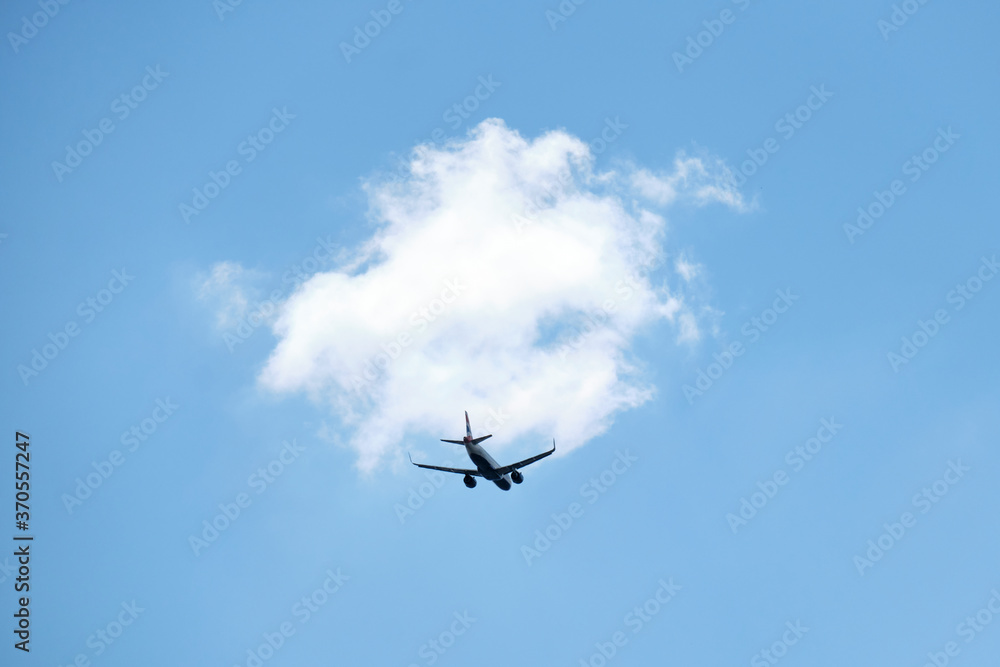 From below of aircraft flying with blue and cloudy sky From below of aircraft flying with blue and cloudy sky