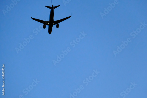 From below of aircraft flying with blue sky on background