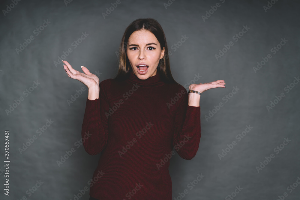 Young misunderstanding woman with raised hands