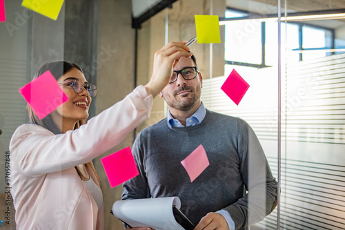 Shot of colleagues having a brainstorming session with sticky notes at work. Working their way through different solutions. 