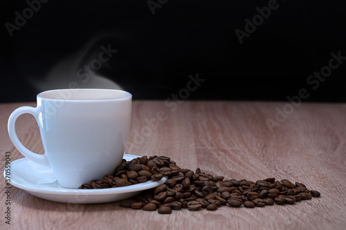 Close-up of a coffee Cup and scattered coffee beans.