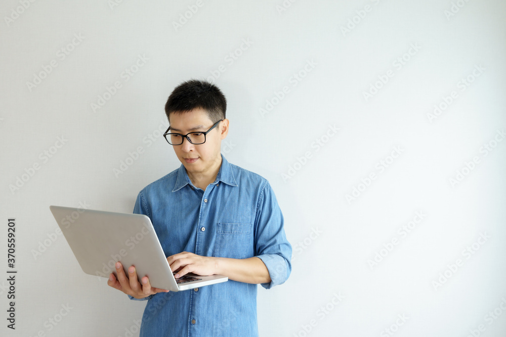 Side view Portrait of happy young businessman holding in hands laptop working at office. looking at laptop computer screen.