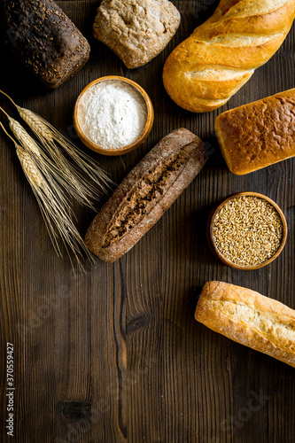 Different kinds of fresh bread on kitchen table top view space for text