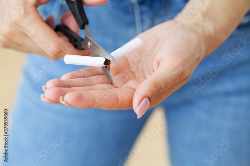 Stop smoking  young girl holding broken cigarette in hands.