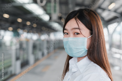 Asian woman wearing a mask stands in railcar waiting for an railcar in the subway. Unemployed young women holding a job application. Travel using railcar concept, Unemployment concept, Business idea.