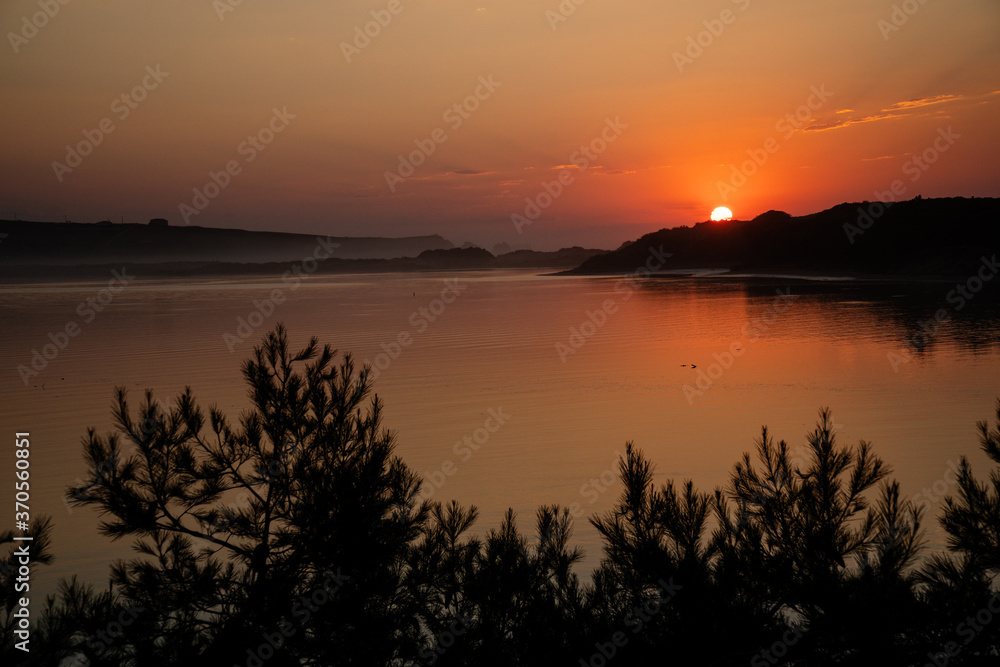 Obraz premium Beautiful orange sunset in the river to the sea