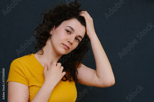 Portrait of young cute emotional caucasian female on grey background.