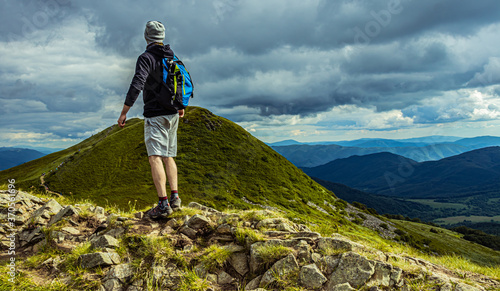 Fototapeta Naklejka Na Ścianę i Meble -  Hiker at the top of the mountain. Man standing on the rock. Bieszczady Poland. 